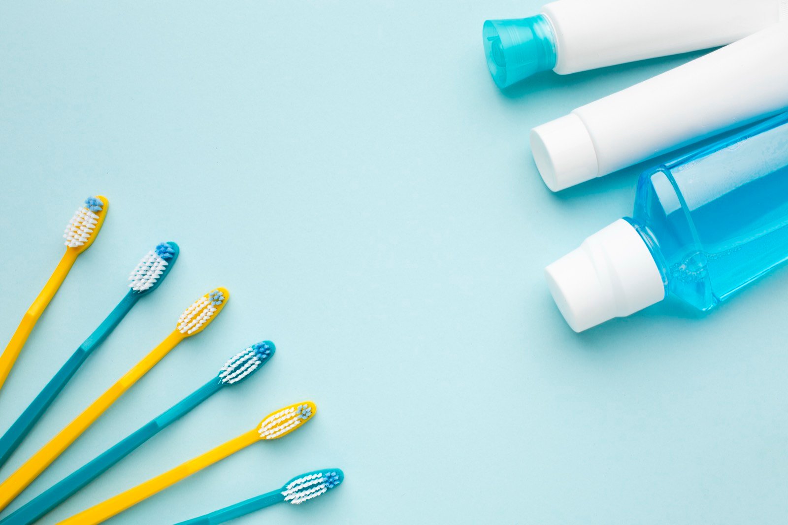 Escova de dente e fio dental sobre superfície clara